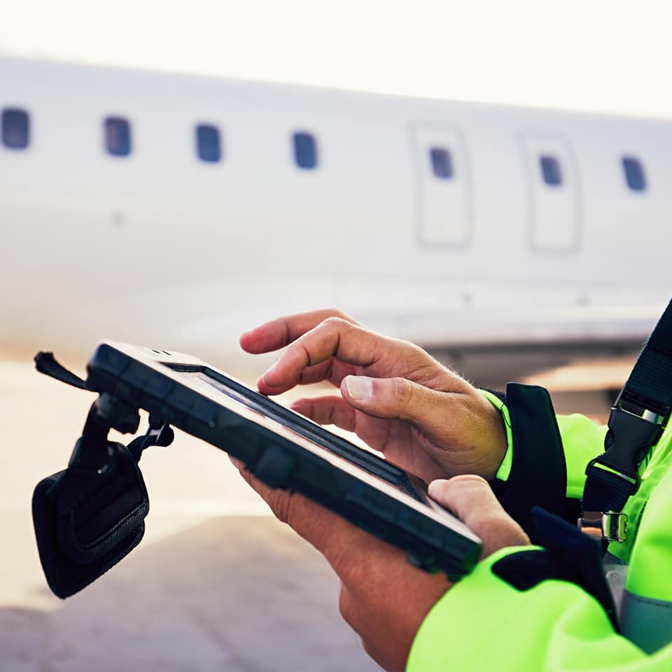 ATC holding tablet. Air traffic controller using tablet outside on runway.